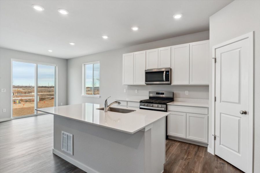 A kitchen with white cabinets.