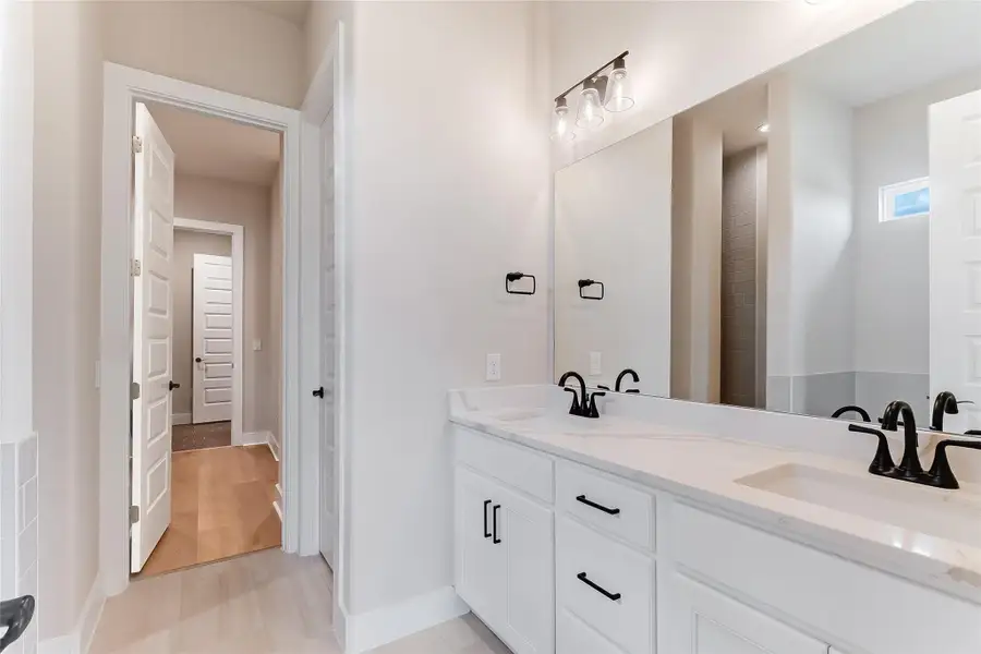 Bathroom featuring double vanity and baseboards