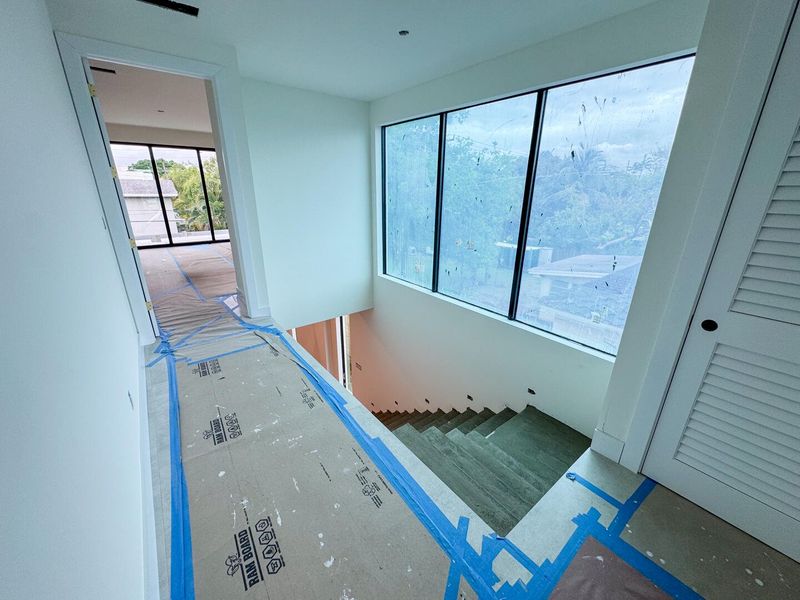 (as of April 8, 2026) the second level is seamlessly connected by the floating concrete staircase, with light pouring in from the full-height picture windows