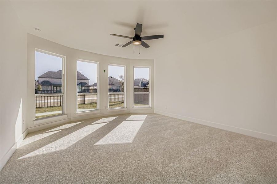 Empty room with carpet, a ceiling fan, and a residential view