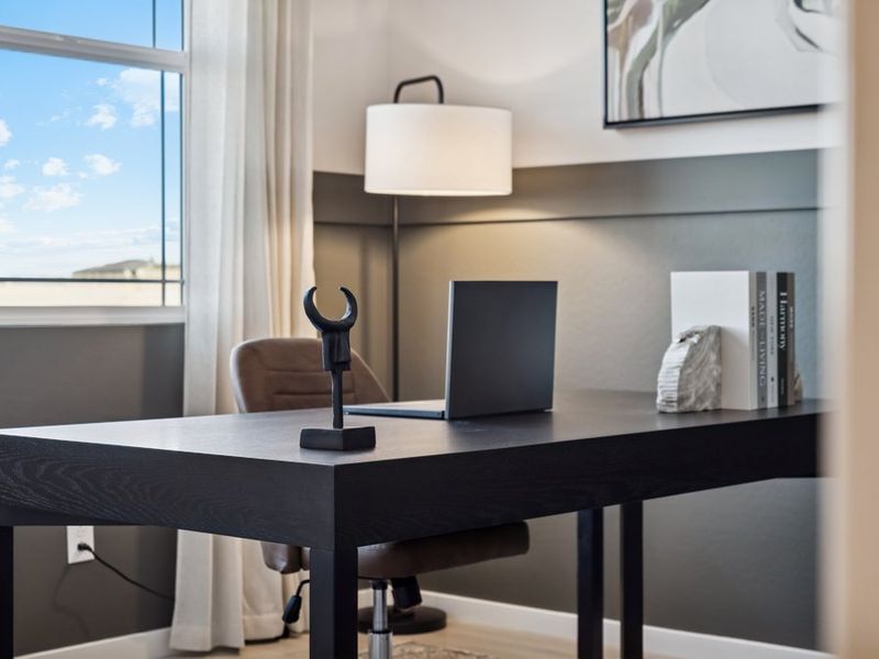 A desk with a computer and a lamp on it.