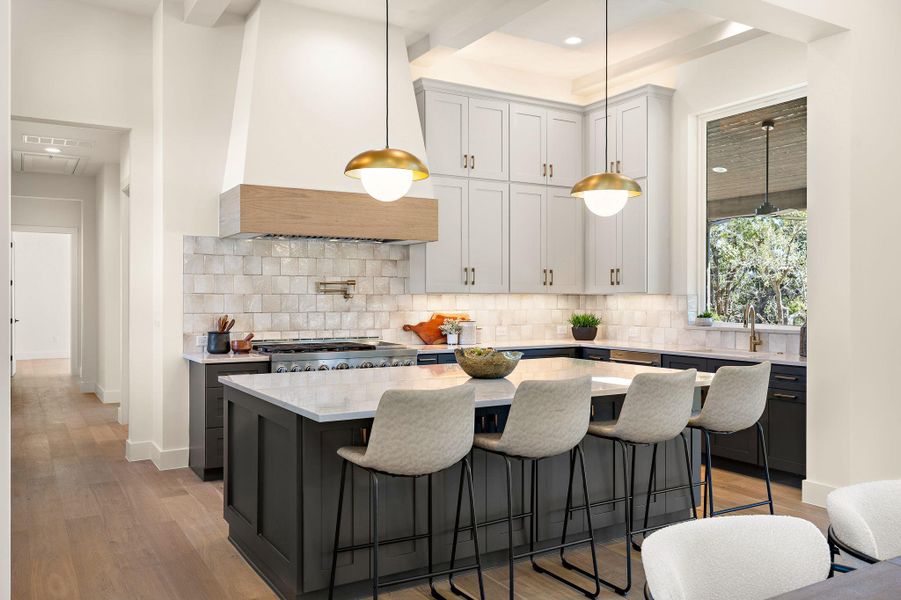 Kitchen with light wood-style flooring, custom range hood, stove, and a sink