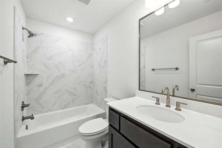 Full bathroom featuring vanity, marble finish floors, and  shower combination