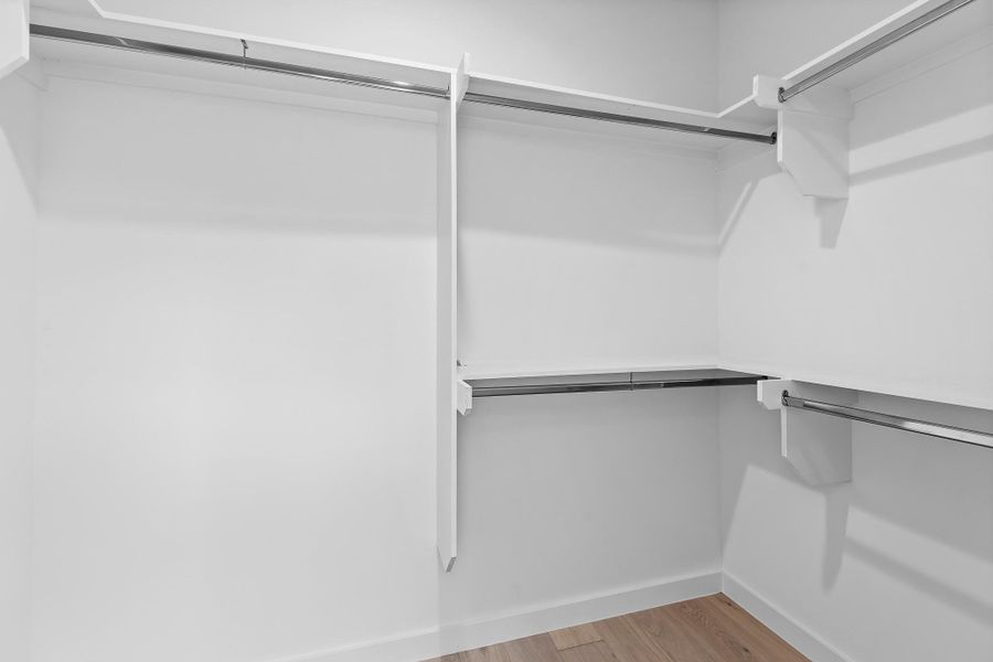 Ample hanging space and shelving create an organized walk-in closet system.