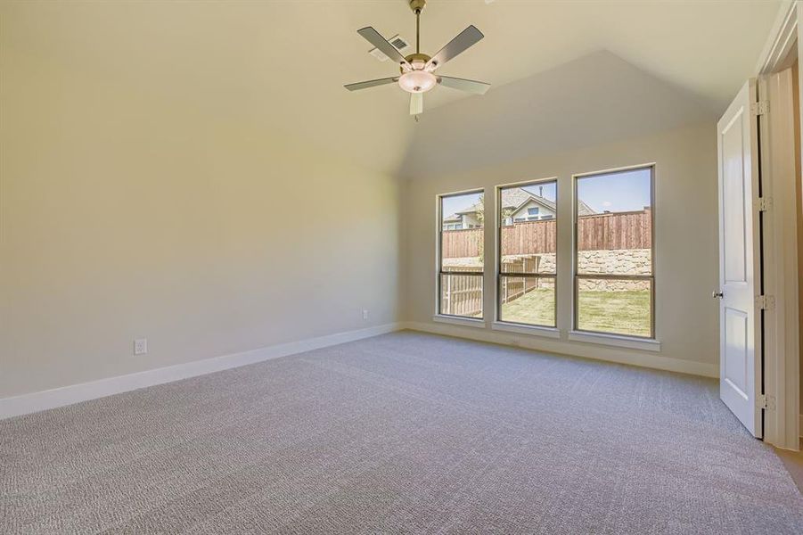 Unfurnished room featuring light carpet, ceiling fan, and high vaulted ceiling