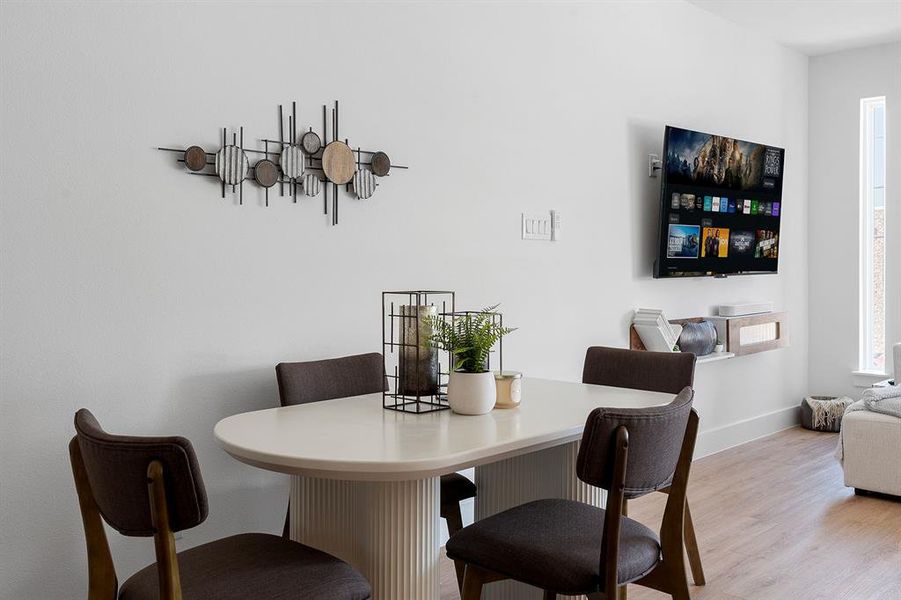 Dining area featuring a white oval table with a fluted pedestal base