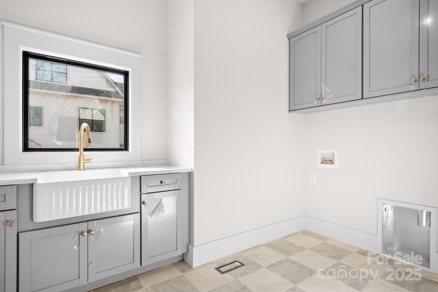 Even chores feel elevated in this thoughtfully designed laundry room that offers a farmhouse sink and cabinetry.