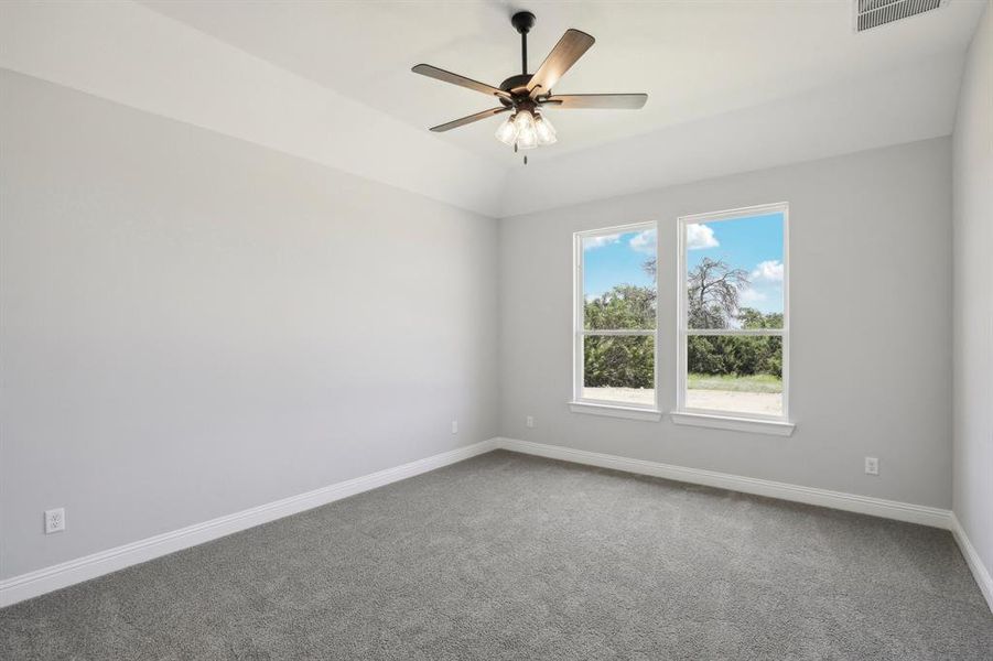 Carpeted spare room featuring ceiling fan