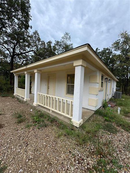 View of front of home with covered porch and central air condition unit