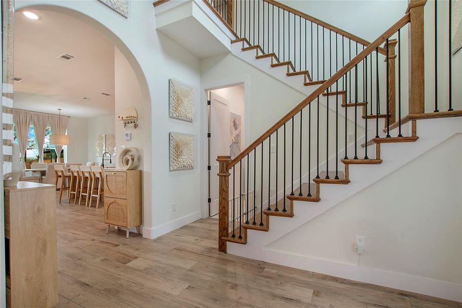 Foyer entrance featuring arched walkways, light wood-style floors, recessed lighting, and stairs Foyer entrance featuring arched walkways, light wood-style floors, recessed lighting, and stairs