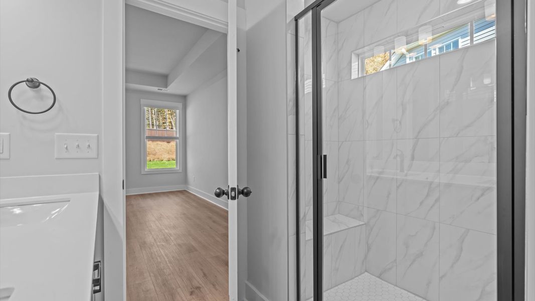 Exceptional en-suite with dual vanity and glass-enclosed tiled walk-in shower for superior everyday comfort