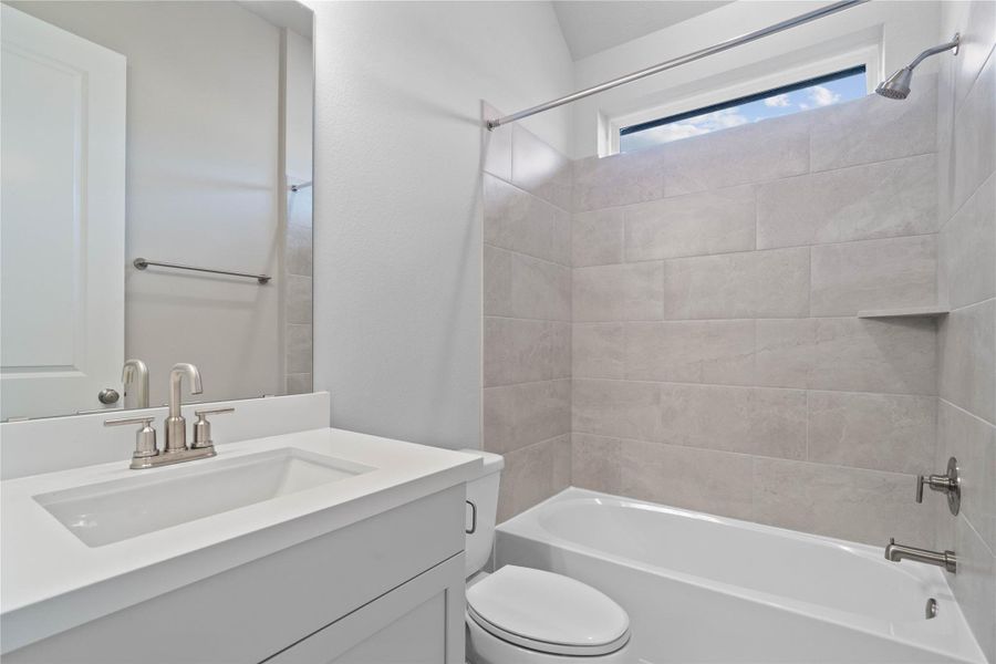 This ensuite secondary bathroom features a modern vanity, tub/shower combination with tile surround, and brushed nickel finishes.