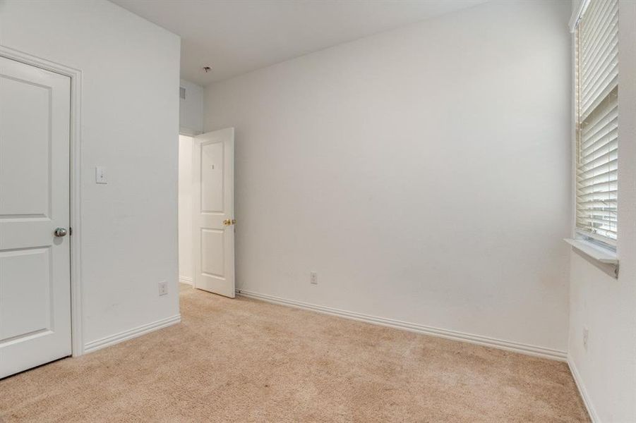 Unfurnished bedroom featuring light colored carpet and baseboards