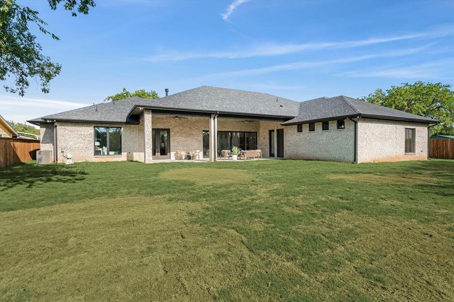 Back of house with a lawn and a patio area