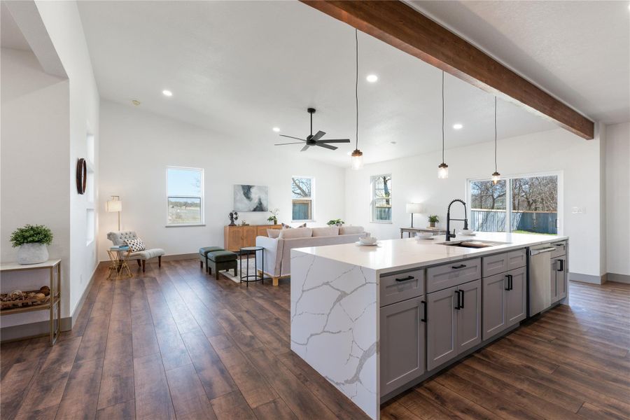 Kitchen featuring a wealth of natural light, gray cabinetry, stainless steel dishwasher, and a sink