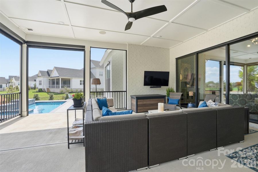 Covered porch with motorized screens leading out to pool and backyard
