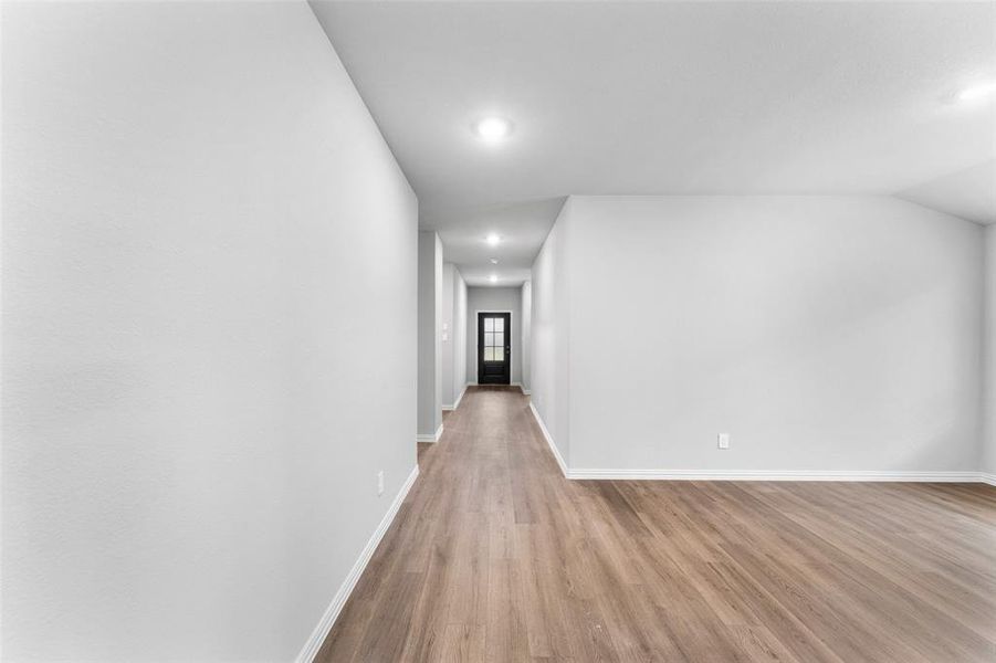Hallway with light wood finished floors and recessed lighting Hallway with light wood finished floors and recessed lighting
