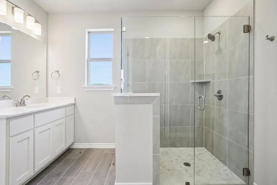 Bathroom with wood tiled floors, vanity, and a shower stall