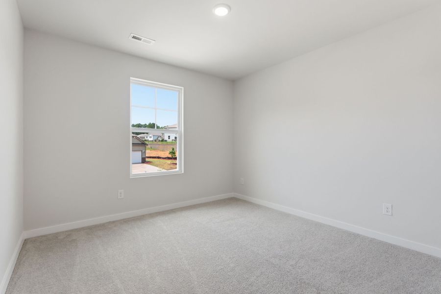 A room with a window and a white wall.