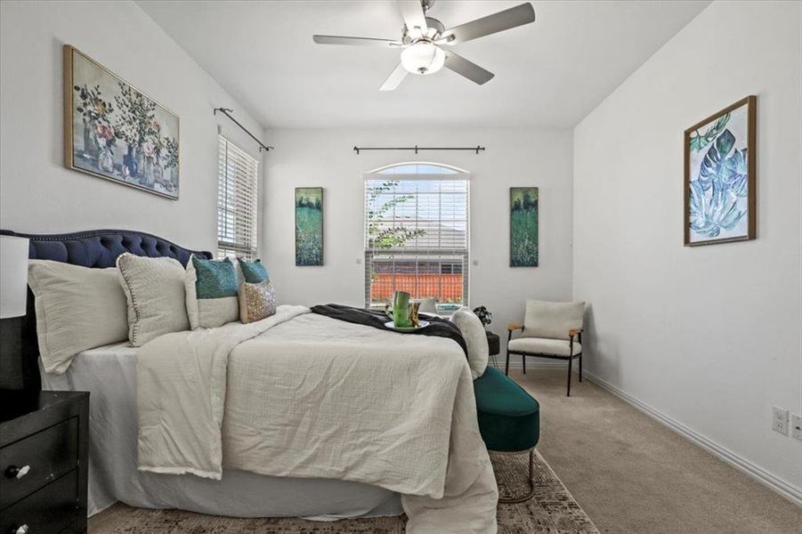 Carpeted bedroom featuring baseboards and a ceiling fan Carpeted bedroom featuring baseboards and a ceiling fan