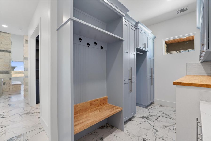 Mudroom featuring recessed lighting and light marble finish flooring