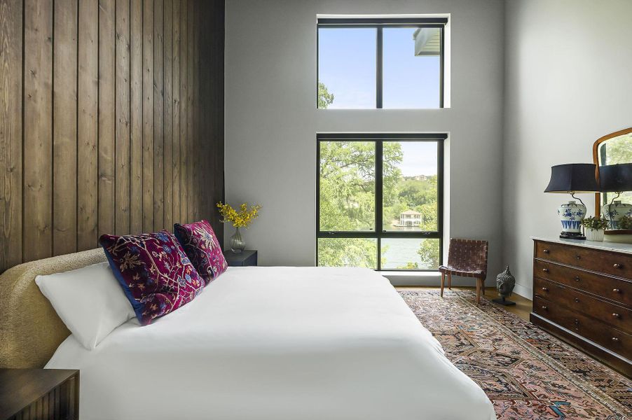 Roomy primary suite with tall ceilings, moody decor, handsome pendant lighting and automated shades. Though you will want to keep those up for that spectacular view!