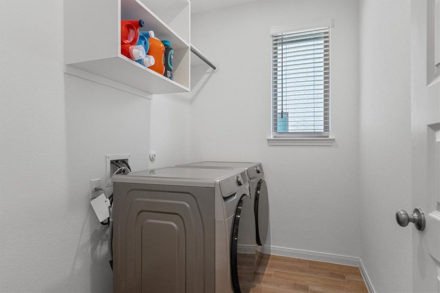 Laundry room featuring washer and clothes dryer and light wood finished floors