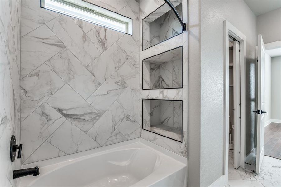 Bathroom with marble finish floors and baseboards