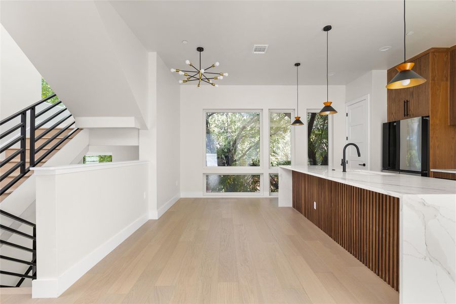 Gleaming hardwood floors and a waterfall-edge island anchor this modern kitchen.