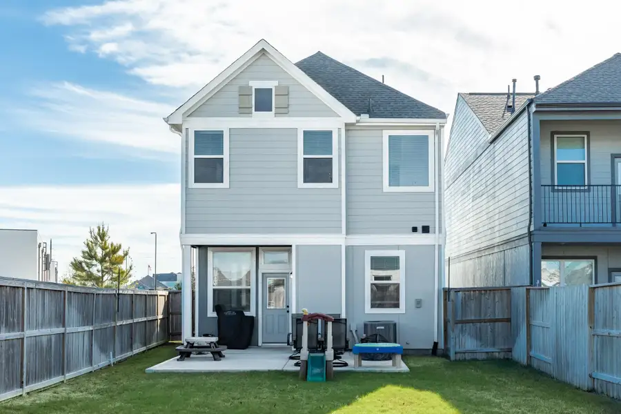 Rear of home with covered patio, oversized backyard.