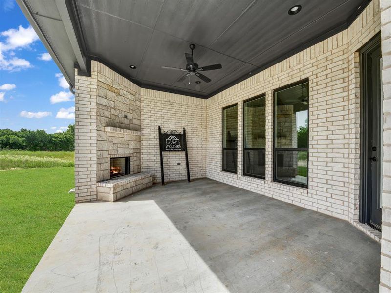 View of patio / terrace featuring an outdoor stone fireplace and ceiling fan View of patio / terrace featuring an outdoor stone fireplace and ceiling fan
