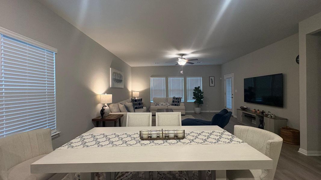 An open floorplan seamlessly connects the dining and living areas, bathed in natural light.