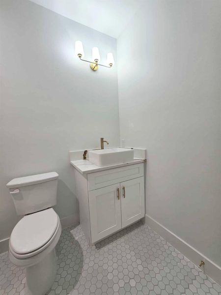 Half bath with vanity and light tile patterned floors