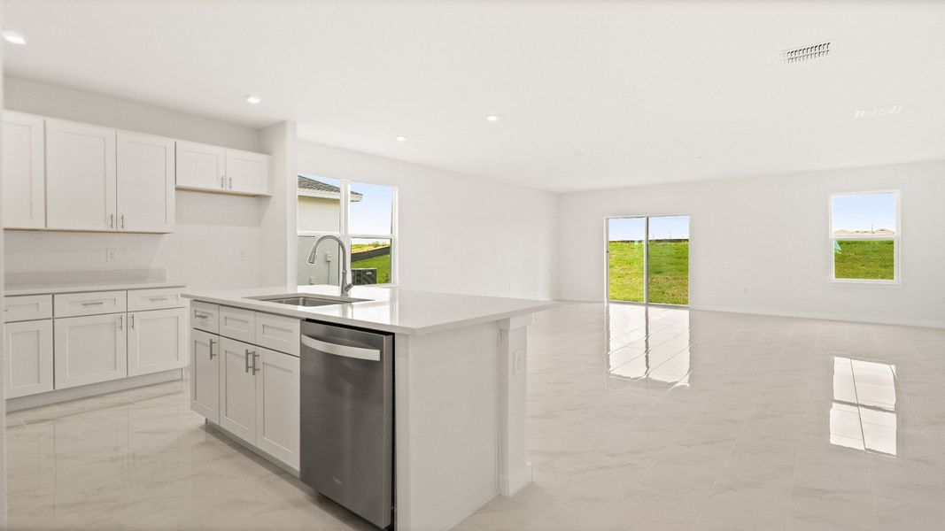 Bright open-concept layout with tile floors and modern kitchen in the Castaway model