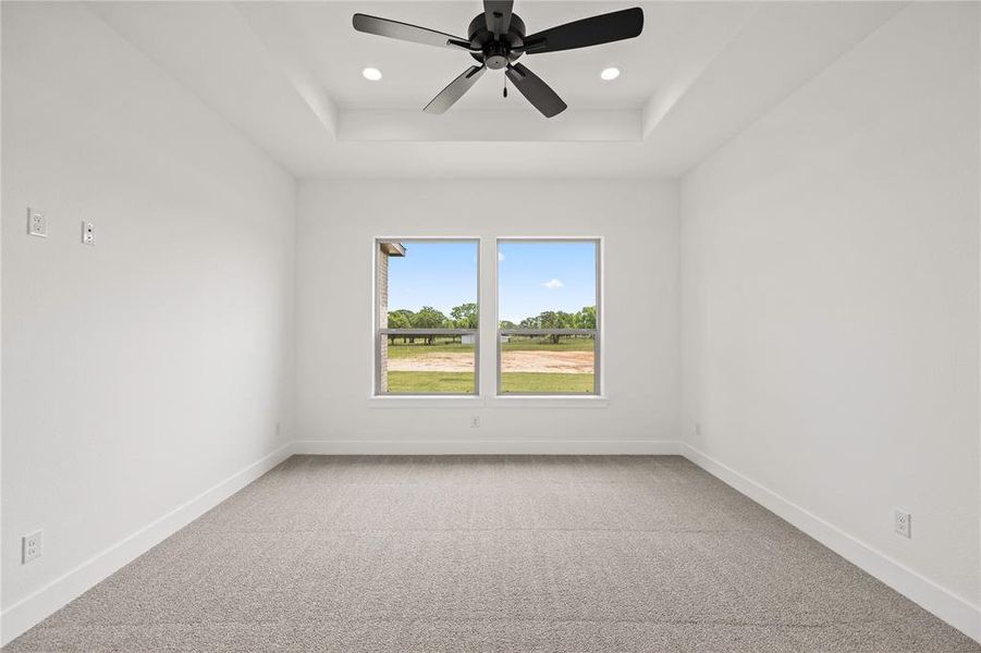 Spare room featuring light colored carpet, a raised ceiling, recessed lighting, and a ceiling fan Spare room featuring light colored carpet, a raised ceiling, recessed lighting, and a ceiling fan