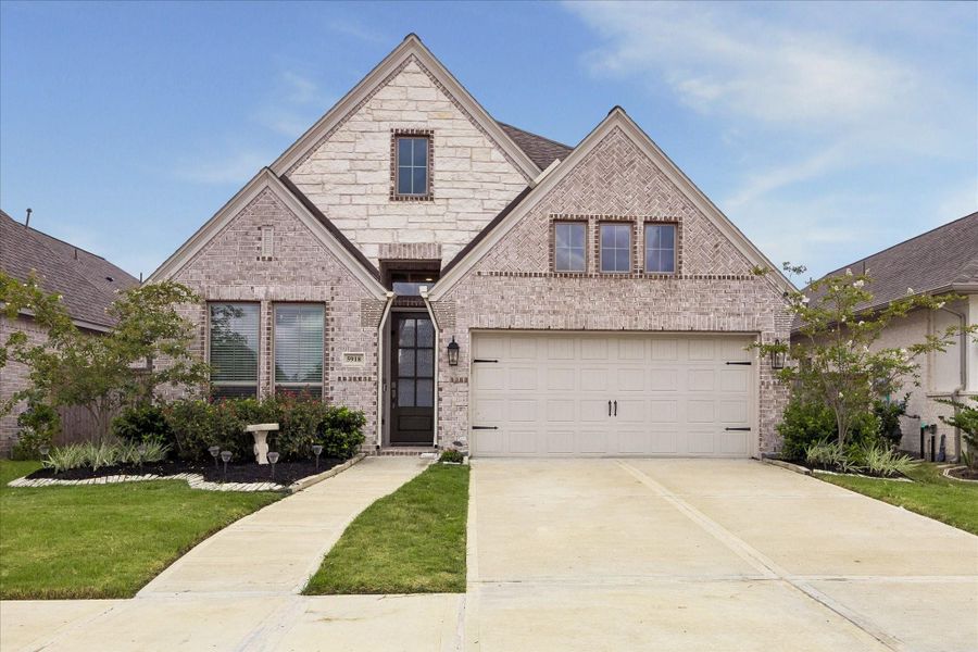 Front exterior of a new home in Valencia, Manvel, TX, highlighting curb appeal (Image 1). Front exterior of a new home in Valencia, Manvel, TX, highlighting curb appeal (Image 1).