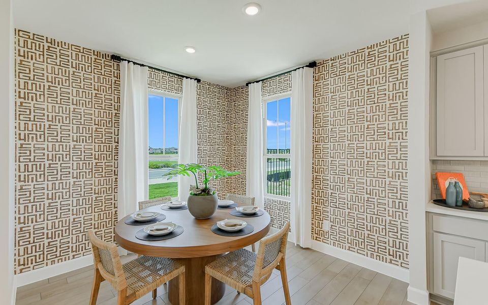 Dining room with light wood finished floors and recessed lighting
