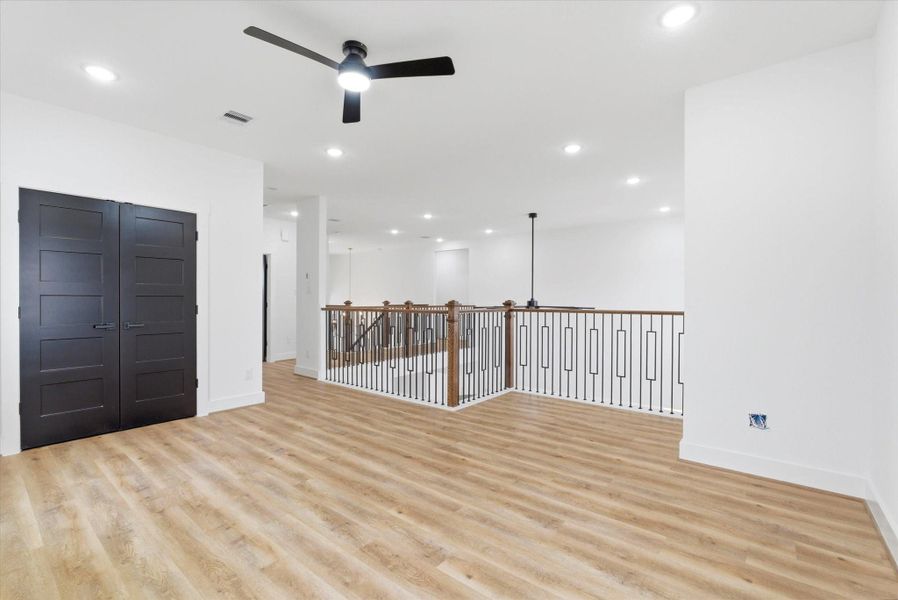 Second-floor game room with an included laundry room, offering ample storage and the convenience of washer and dryer connections to accommodate either upstairs or downstairs living.