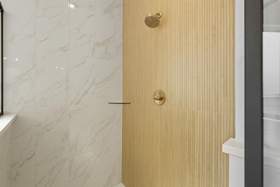 Full bath with a marble finish shower