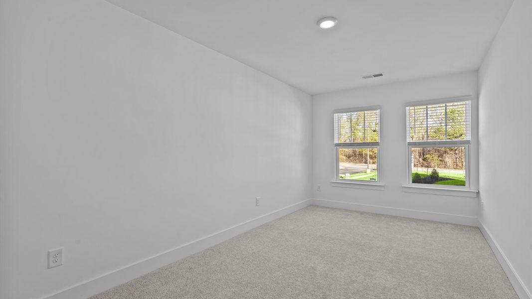 Vibrant and inviting secondary bedroom featuring a walk-in closet and refined finishes