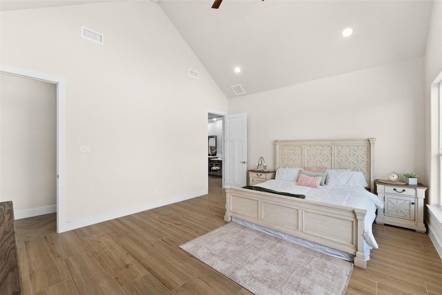 Bedroom featuring high vaulted ceiling, light wood finished floors, ceiling fan, and recessed lighting