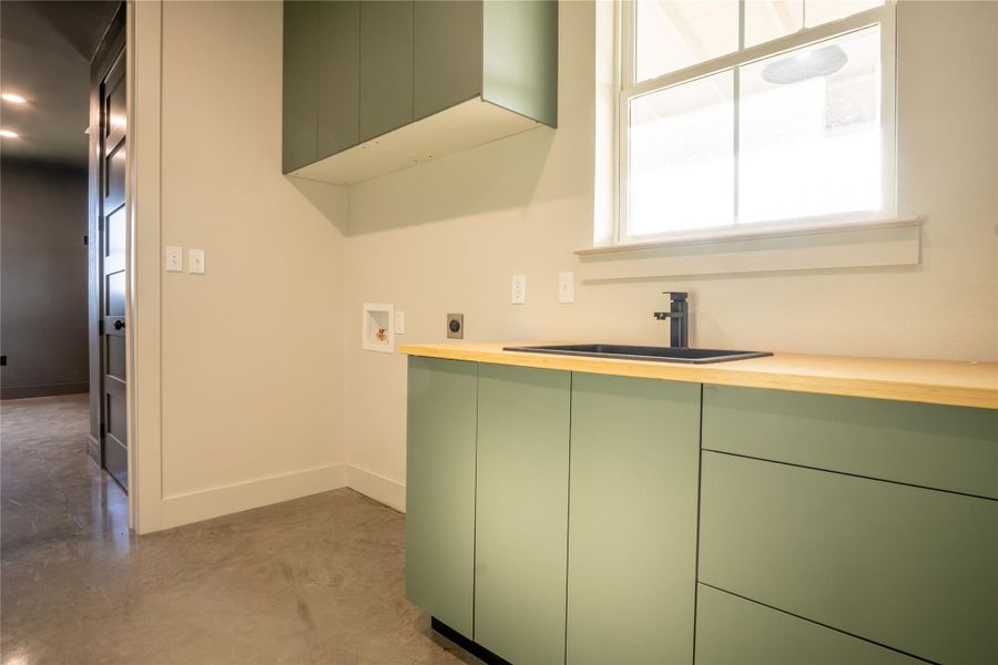 Laundry area with hookup for an electric dryer, cabinet space, plenty of natural light, and hookup for a washing machine