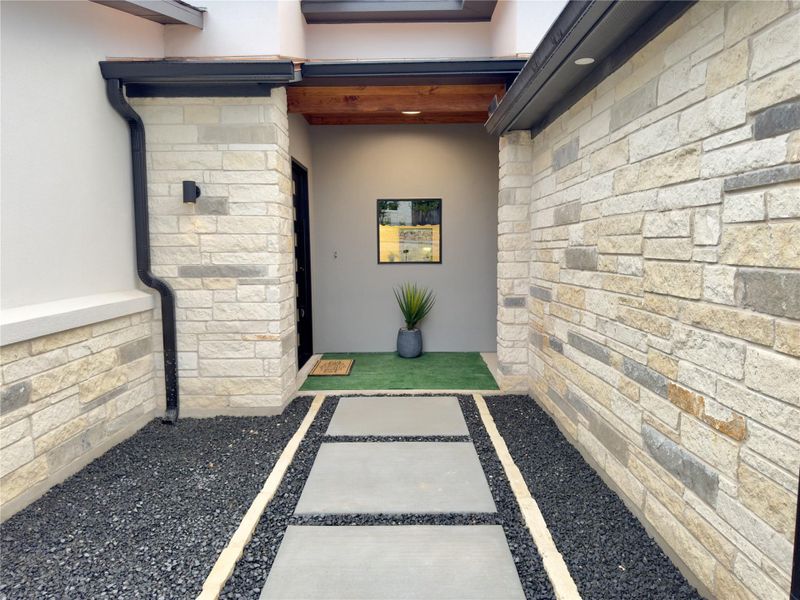 Property entrance with stucco siding and stone siding Property entrance with stucco siding and stone siding