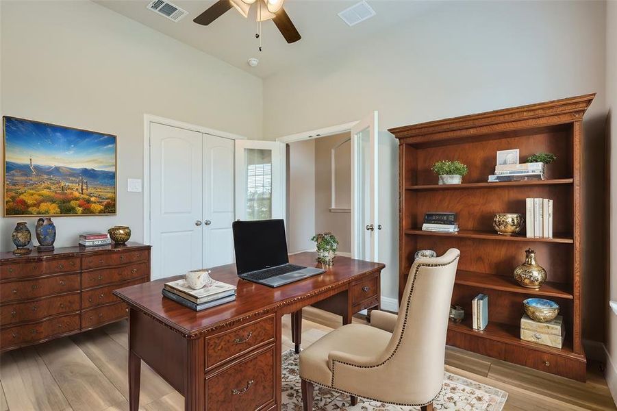 Home office with light hardwood / wood-style flooring and ceiling fan