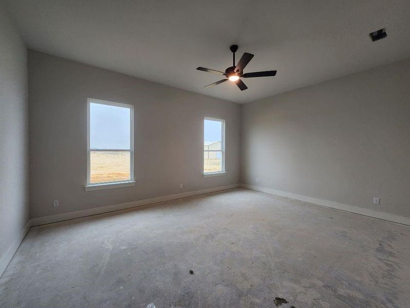 Spare room with unfinished concrete floors and a ceiling fan