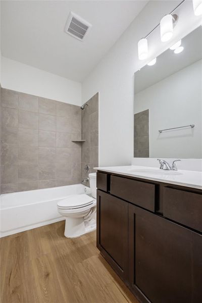 Full bathroom featuring vanity, tub / shower combination, and light wood-style floors Full bathroom featuring vanity, tub / shower combination, and light wood-style floors