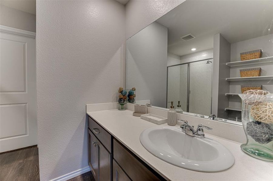 Bathroom with vanity, hardwood / wood-style flooring, and an enclosed shower