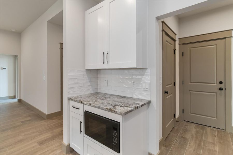 Built-in microwave into lower cabinets; view of doors to pantry and laundry