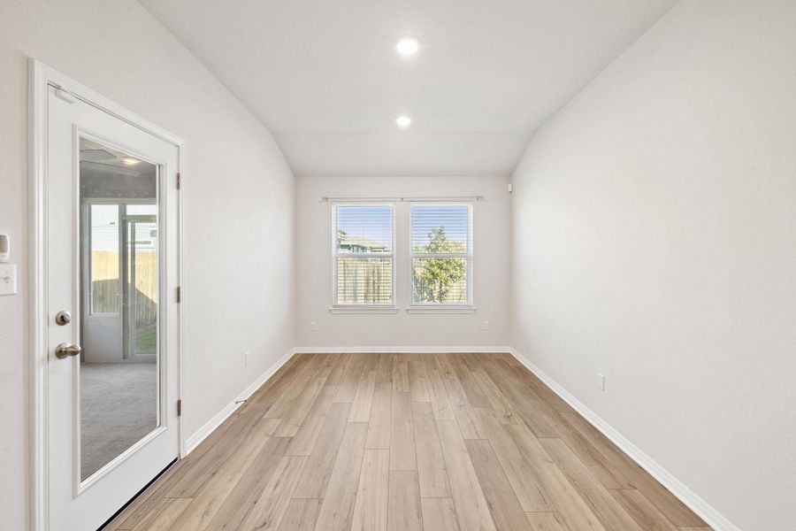 Unfurnished room with light wood-style floors, lofted ceiling, and recessed lighting Unfurnished room with light wood-style floors, lofted ceiling, and recessed lighting