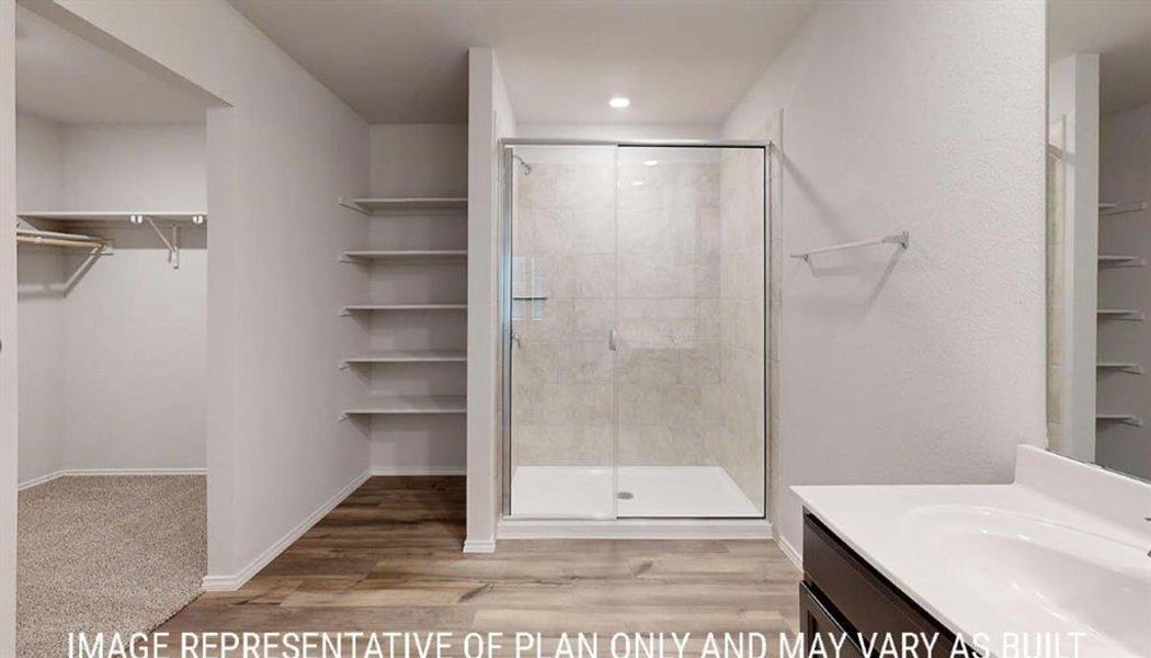 Walk-in shower with clear glass enclosure and light-toned tile surround